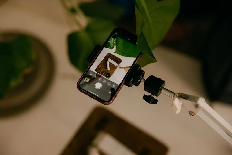 Smartphone mounted on a stand photographing a small product from above